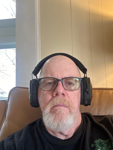 Reviewer wearing the black MX PRO earmuff protection while relaxing indoors.
