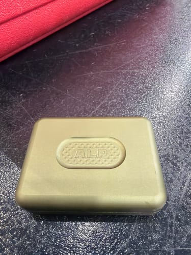 Customer's military green Premium Slide Case, shown in a close-up on a dark tabletop.