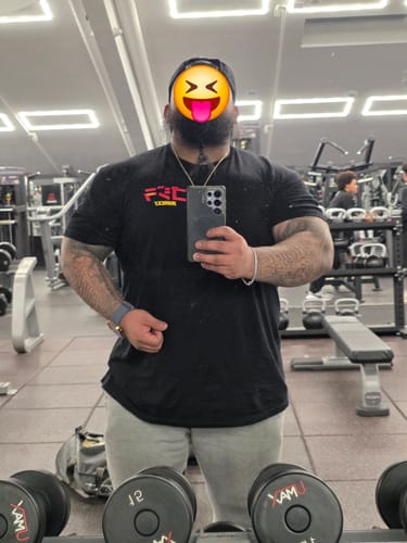Customer wearing the black RAMEN MONSTER TEE while taking a mirror selfie in a gym.
