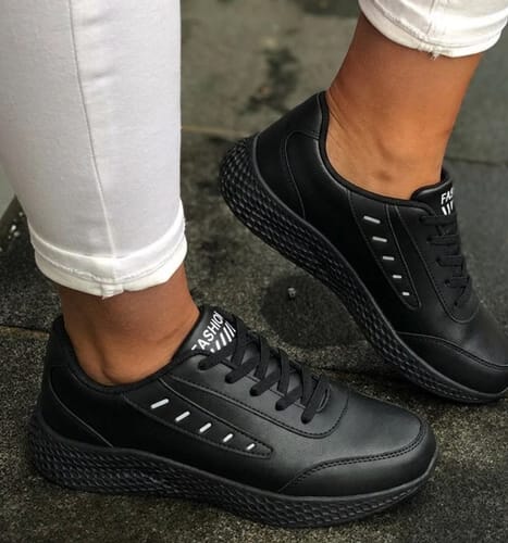 Customer wearing the black Soft Stride sneakers, highlighting the lace-up design and textured sole.