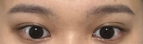 顧客配戴 Quiet Kristin 1Day 黑色隱形眼鏡的特寫，鏡片與深色眼珠自然融合。