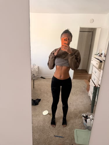 Reviewer taking a mirror selfie of the black Seamless LowRise Legging, showing the low waist and foot holes.