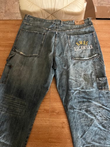 Customer's baggy, light-wash jeans from the Y2K Men's Mix, showing the Rocawear brand on the back pocket.