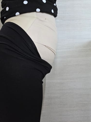 A customer's side view showing the beige Lovemere Postpartum Tummy Wrap Binder worn around their waist under clothing.