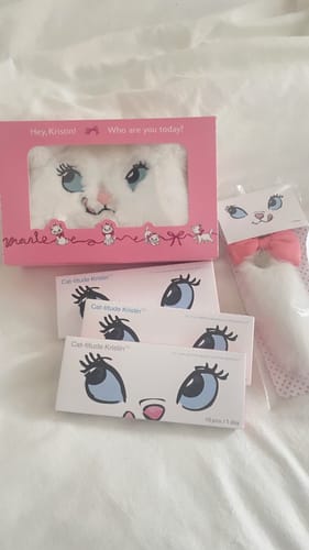 購入者のふわふわなディズニーマリーファーポーチ。ピンクの箱に入ったポーチと関連商品が一緒に白い布の上に置かれています。