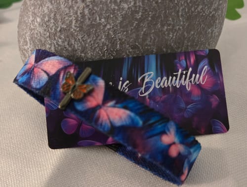 Customer's Change Is Beautiful Bracelet showing its colorful butterfly pattern and charm, displayed with its backing card.