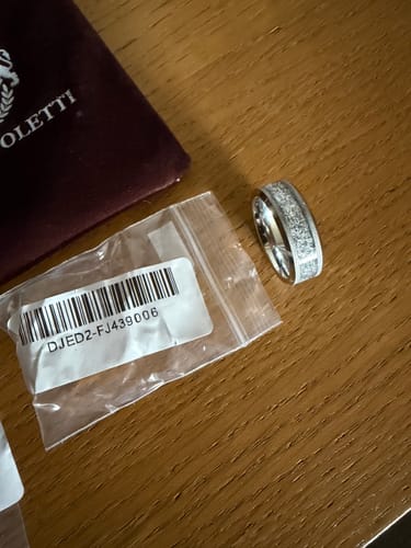 Customer's 8mm Aureum Silver ring on a wooden table next to its packaging.