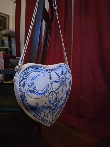 Customer's Cosmic Heart Tote Bag hanging from a chair, showing its detailed blue and white design.