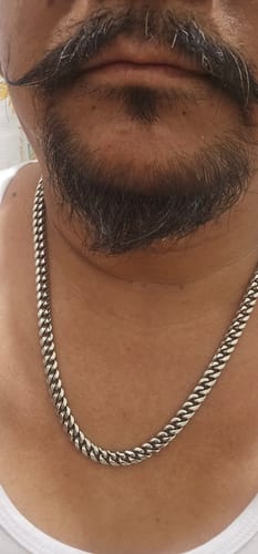 Primer plano de un cliente usando la Cadena Cuban Link de 8mm en el cuello.