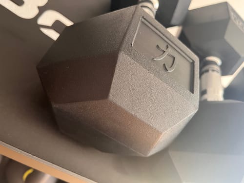 Customer's close-up of a black Hex Dumbbell, showing the textured SBR rubber head.
