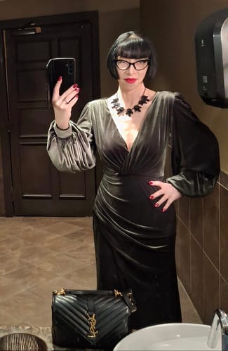 Reviewer takes a mirror selfie in the olive green velvet Film Noir Gown, showing the fit and ruched details.