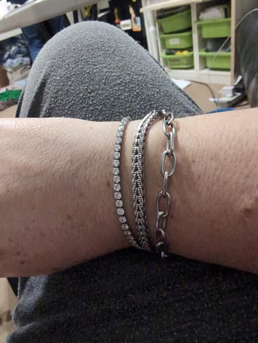 Customer wearing the Link Chain Bracelet on their wrist, layered with two other silver-toned bracelets.