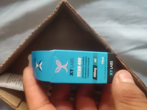 Cliente sosteniendo el empaque azul y negro del producto TITAN 400 de XT Labs.