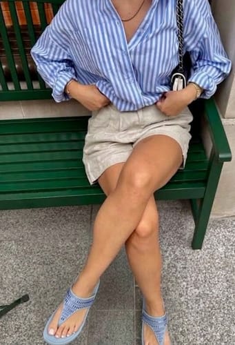 Customer wearing light blue Drift sandals while seated on a bench.
