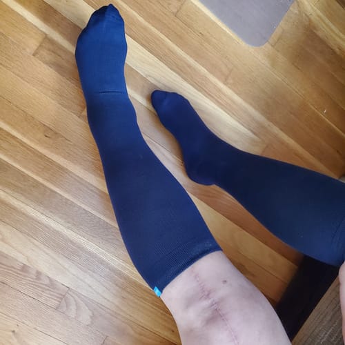 Reviewer wearing the navy blue Performance Eucalyptus Compression Socks on their legs.