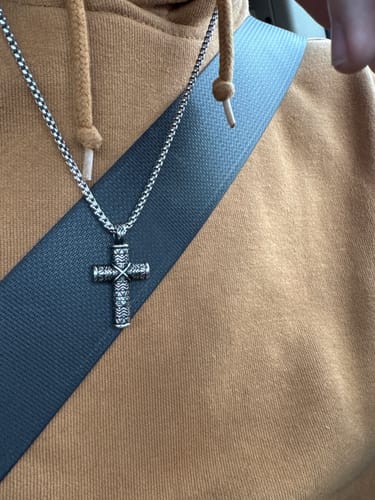 Reviewer wearing the Detailed Cross Urn Pendant, showing the intricate design and boxy chain.