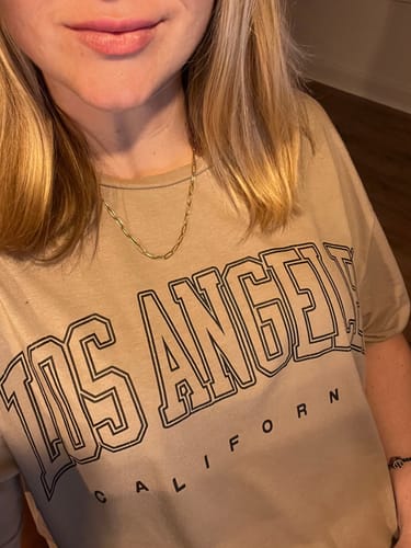 Reviewer wearing the gold Maui Paperclip Necklace on its own with a casual t-shirt.