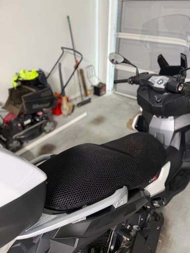 Customer's black mesh Wind Rider Seat Cover fitted on their scooter in a garage.