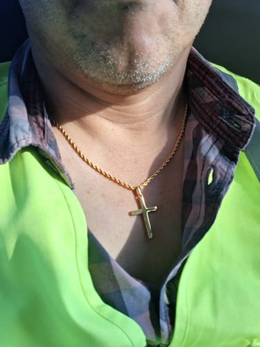 Un cliente lleva puesto su colgante Crucifix Pendant Oro sobre una camisa.