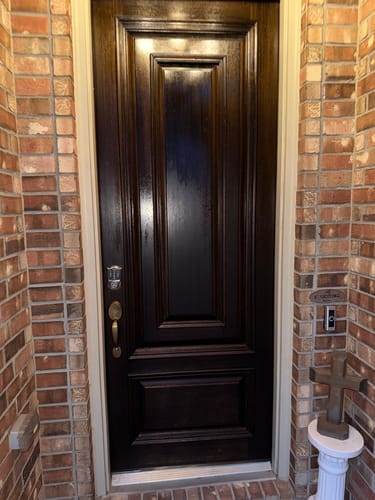 Reviewer's solid wood entry door before installing the Clear 8 Lite Glass and Frame Kit.