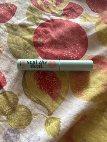 Ein Bewerter zeigt den 'seal the deal.' Top Coat auf einem Tuch mit Fruchtmuster.