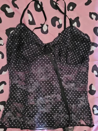 Reviewer shows a black polka dot camisole with lace details, an item received in their Angel Bag.