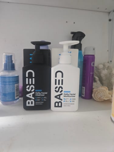 Customer's Daily Skincare Duo, the black cleanser bottle and white moisturizer bottle, on a bathroom shelf.