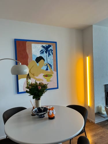 Recensent toont het HKliving Catch My Drift Schilderij hangend aan een muur boven een eettafel.