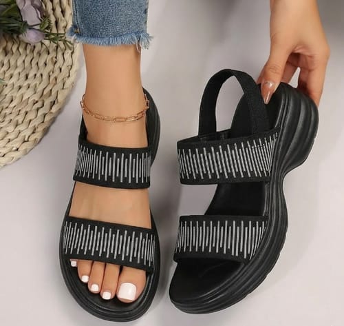 A customer wearing the black Steady sandals with patterned straps, showing the thick, cushioned sole.