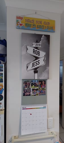 Customer's personalized black-and-white canvas showing street signs with the names 'Rob' and 'Jess', hanging on a wall.