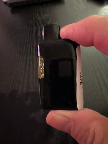 Close-up of a customer holding a black vape from The Flow Vape Pack in their hand.
