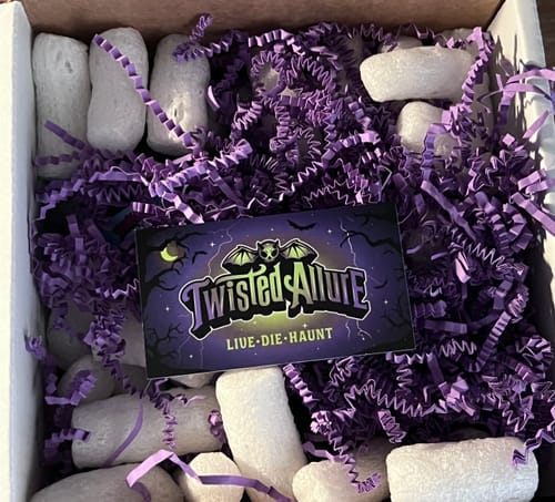 Customer's shipping box filled with purple crinkle paper and packing peanuts before unboxing.
