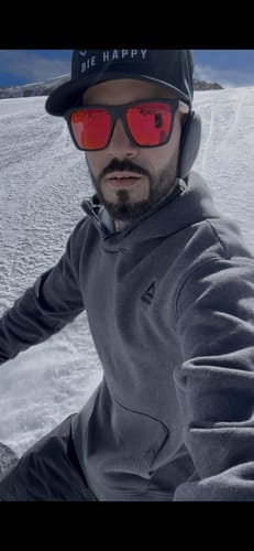 Reviewer wearing the 80Eighty Polarized Bamboo Sunglasses with red lenses on a snowy slope.
