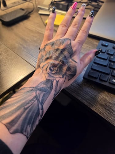 Customer's hand showing a large rose tattoo after using the Painless Tattoo Numbing Cream for the procedure.