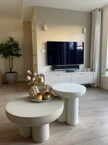 Klant toont het beige TV-Meubel Lima opgesteld in een stijlvolle woonkamer onder een tv.