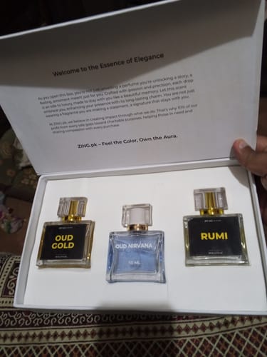Customer holds open the OUD Supreme BUNDLE box, revealing the three included perfume bottles.