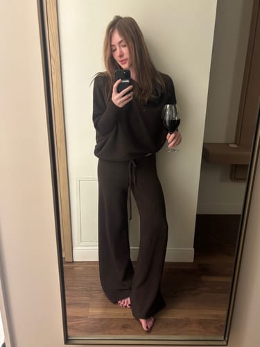 Reviewer taking a full-length mirror selfie in the espresso brown Asymmetric Draped seamless knit set.