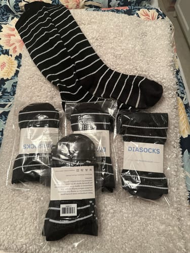 Kundens svart- och vitrandiga Diasocks stödstrumpor, ett par uppackade och flera par kvar i sina förpackningar.