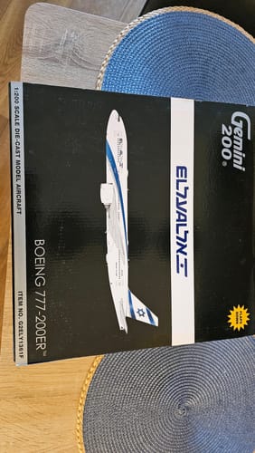 Customer shows the packaging for the GEMINI EL AL 777-200ER model airplane on a table.
