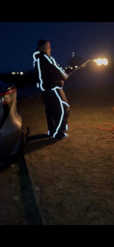 Reviewer wearing the baggy snow pants at night, with the reflective piping glowing brightly.
