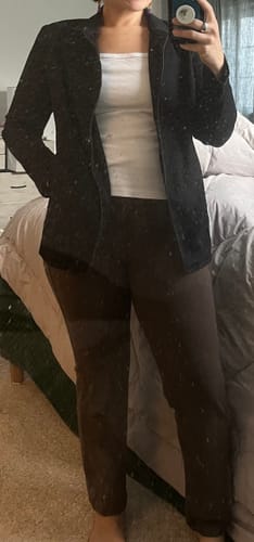 Reviewer showing the fit of the brown Emerson Straight Leg Pants, styled with a white top and dark jacket.