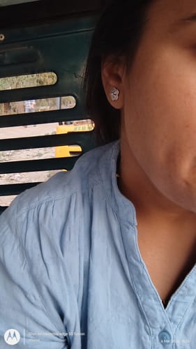Reviewer wearing the small, flower-shaped Silver Flora Fiesta Earring in their ear.