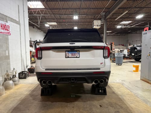 Reviewer's white Ford Explorer ST in a garage with the SPE Motorsport Axle Back Exhaust installed.