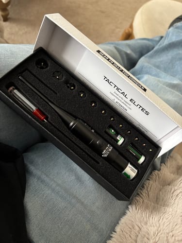 Customer holds the open box for the Site Right™ 2.0 - Boresighter, showing the kit with attachments and batteries inside.