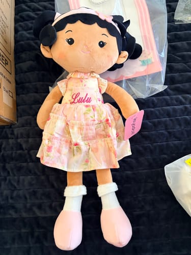 Customer's personalized Leya Doll with the name 'Lulu' embroidered on its pink floral dress.