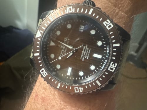 Close-up of a customer's Oceaneva Pro Diver watch, showing the aged bronze dial on an OD green strap.