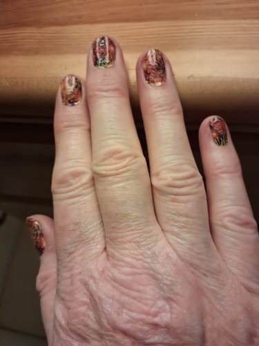 Kundin zeigt ihre fertige Maniküre mit den Spectacular Evening Nagelfolien.