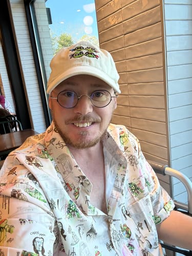 Reviewer smiling while wearing the 'Heroes in a Half Sketch' shirt, showing the detailed, hand-drawn TMNT pattern.