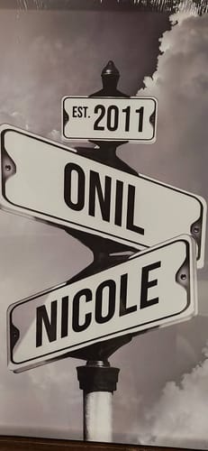 Customer's personalized black-and-white canvas with street signs showing the names 'Onil,' 'Nicole,' and the year '2011'.