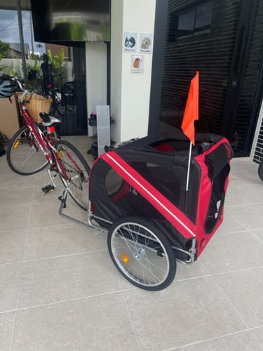 Customer's red and black Pet Trailer Bike, assembled and attached to a bicycle on an outdoor patio.